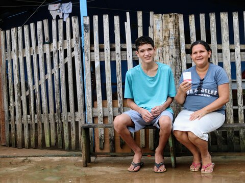 Mother and son on bench outside health centre in Brazil