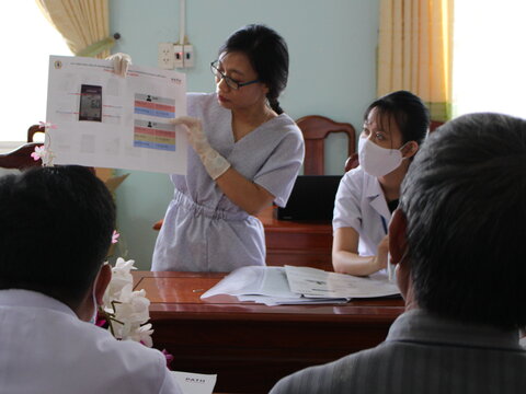 Woman conducting training session - showing materials to participants 